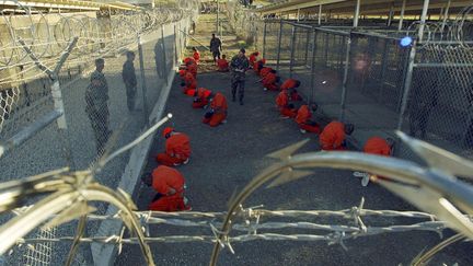 Des d&eacute;tenus en combinaison orange dans le centre de d&eacute;tention de Guantanamo, sur l'&icirc;le de Cuba, le 11 janvier 2002.&nbsp; ((STEPHAN WERMUTH/REUTERS))