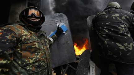 Les manifestants arborent des tenues de combat faites de bric et de broc, comme cet homme qui porte des lunettes de ski. (YANNIS BEHRAKIS / REUTERS)