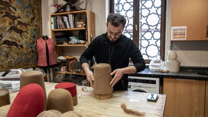 Yunus Girgic travaille dans un atelier avec des moules utilisés pour fabriquer le "Sikke" porté par les derviches tourneurs à Konya, le 17 décembre 2023. (OZAN KOSE / AFP)