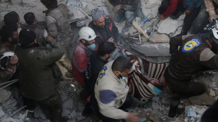 Des secouristes évacuent une victime des décombres d'un hôpital bombardé à Marat Al-Numan (Syrie), le 15 février 2016. (MUHAMMED KARKAS / ANADOLU AGENCY / AFP)