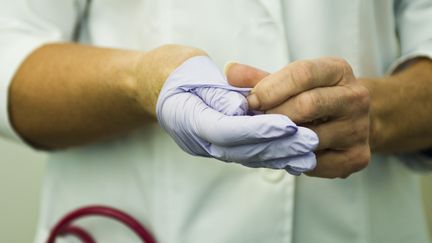 Personnel soignant retirant ses gants d'examen. (MICHÈLE CONSTANTINI
 / MAXPPP)