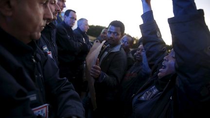 Les migrants cherchent &agrave; faire entendre leur voix. Pendant une manifestation, une migrante africaine crie des slogans devant des policiers fran&ccedil;ais sur une autoroute de Calais le 7 ao&ucirc;t 2015. La prochaine &eacute;tape est souvent l'Angleterre, r&ecirc;v&eacute;e en eldorado par les migrants. (JUAN MEDINA / REUTERS)