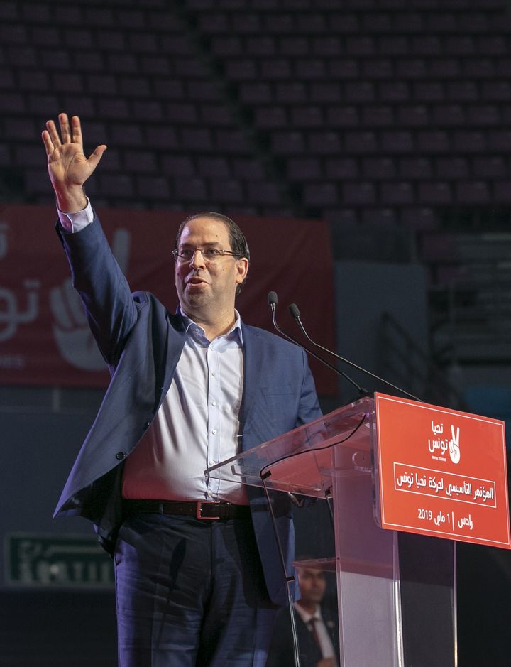 Le Premier ministre tunisien, Youssef Chahed, salue ses partisans lors du congrès fondateur de son parti,&nbsp;Tahya Tounes (Vive la Tunisie), le 1er mai 2019 à Tunis. (AFP - YASSINE GAIDI / ANADOLU AGENCY)