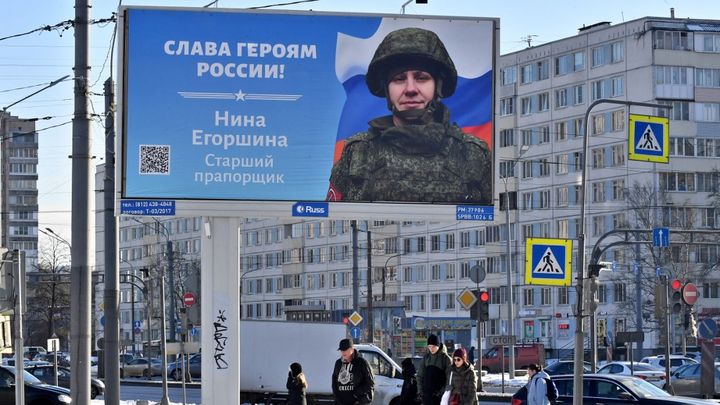 Une affiche rendant hommage à une soldate russe, dans une rue de Saint-Pétersbourg (Russie), le 27 février 2023. (OLGA MALTSEVA / AFP)