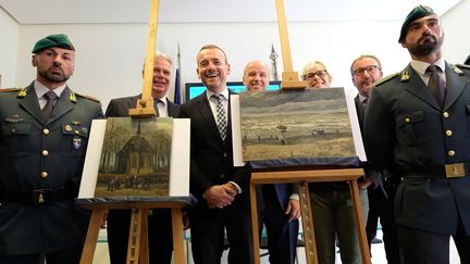 Les deux tableaux de Van Gogh volés en 2002, retrouvés en Italie : "Sortie de l'église de Nuenen" de 1884 et "Vue de la mer de Scheveningen (tempête)" de 1882.  Au centre de la photo, le directeur du musée Van Gogh, Axel Rüger.
 (MARIO LAPORTA / AFP)