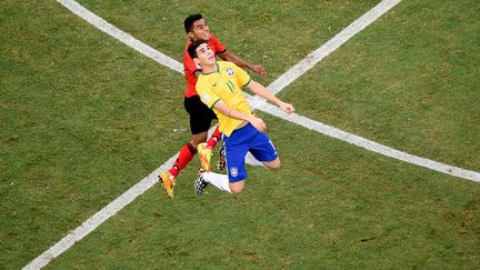 Le milieu de terrain mexicain Jos&eacute; Juan Vazquez (G) et son homologue br&eacute;silien Oscar lors du match opposant les deux &eacute;quipes &agrave; Fortaleza, le 17 juin 2014. (FRANCOIS XAVIER MARIT / AFP)