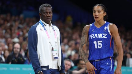 Le sélectionneur de l'équipe de France femmes de basket Jean-Aimé Toupane et l'ailière Gabby Williams lors du match contre l'Australie, lors des Jeux olympiques de Paris, le 4 août 2024. (THOMAS COEX / AFP)