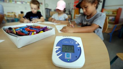 Un éléve dessine non loin d'un capteur de CO2&nbsp;à&nbsp;l'école élémentaire Marcel Pagnol, à Cannes (Alpes-Maritimes), le 25 août 2021. (JEAN FRANCOIS OTTONELLO / MAXPPP)