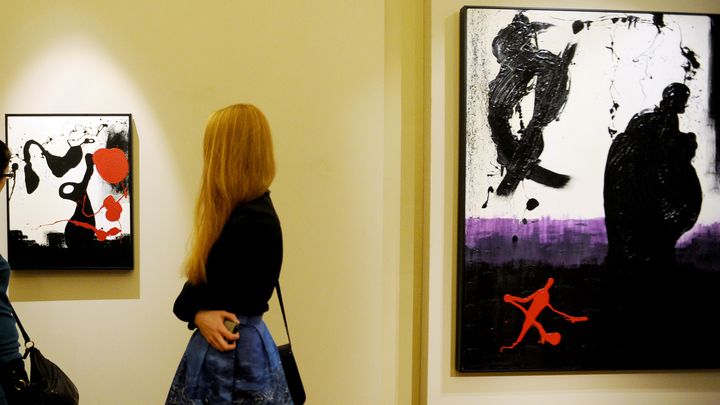 Des visiteurs s'attardent devant des toiles de Sylvester Stallone, le 27 octobre 2013 au Mus&eacute;e russe de Saint-P&eacute;tersbourg. (OLGA MALTSEVA / AFP)