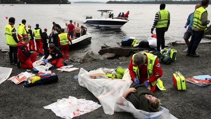 Une femme bless&eacute;e est ramen&eacute;e &agrave; terre, en face l'&icirc;le d'Utaoya (Norv&egrave;ge)&nbsp;: elle vient d'&ecirc;tre sauv&eacute;e apr&egrave;s le massacre du 22 juillet 2012.. (SVEIN GUSTAV WILHELMSEN / AFP)