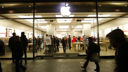 Des passants marchent devant l'Apple Store de Zürich, le 19 décembre 2013, en Suisse. (ARND WIEGMANN / REUTERS)