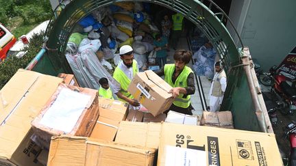 Des bénévoles d'une fondation chargent des boîtes d'aide humanitaire dans un camion pour les personnes touchées par les inondations, à Lahore, le 10 septembre 2022.&nbsp; (ARIF ALI / AFP)