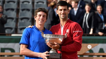 Le Français Geoffrey Blancaneaux, vainqueur du tournoi juniors, pose avec le gagnant de l'épreuve chez les pros, Novak Djokovic, en juin 2016 (PHILIPPE LOPEZ / AFP)