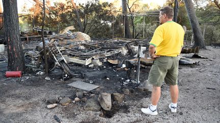 Un homme regarde les d&eacute;g&acirc;ts dans le camping de&nbsp;Bagnols-en-Foret (Var) apr&egrave;s un incendie ayant provoqu&eacute; l'&eacute;vacuation de 10 000 campeurs, mardi 28 juillet 2015. (BORIS HORVAT / AFP)