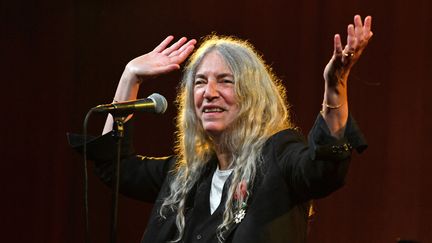 Patti Smith chante après avoir reçu la médaille de la Légion d'honneur, le 21 mai 2022 à New York, dans une bibliothèque publique de Brooklyn (ANDREA RENAULT / AFP)