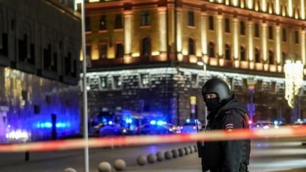 Un policier surveille le dispositif de sécurité installé après une fusillade à Moscou (Russie), le 19 décembre 2019. (DIMITAR DILKOFF / AFP)