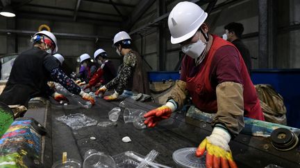 Des ouvriers&nbsp;trient des bouteilles en plastique dans un centre de recyclage des déchets à Hoengseong, le 27 mai 2021. (JUNG YEON-JE / AFP)