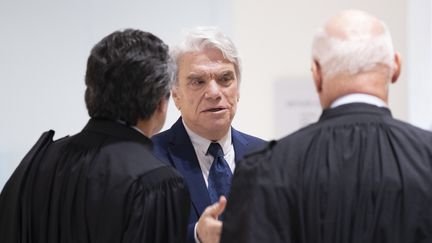 L'homme d'affaires français Bernard Tapie parle à ses avocats alors qu'il quitte le palais de justice de Paris, le 21 mars 2019. (KENZO TRIBOUILLARD / AFP)