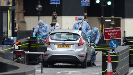 La police scientifique examine la Ford Fiesta qui a servi de voiture-bélier lors de l'attaque à Londres, le 14 août 2018, qui a blessé trois personnes.&nbsp; (DANIEL LEAL-OLIVAS / AFP)