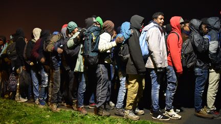 Des migrants attendent des bus pour être répartis dans différents centres en France le 24 octobre 2016 à Calais (PHILIPPE HUGUEN / AFP)