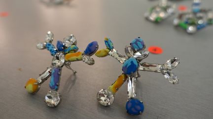 Sur une table à côté sont posés les bijoux, et sous chacun d'entre eux un numéro qui correspond à la silhouette d'un mannequin, pour compléter son look. 
 (Corinne Jeammet)