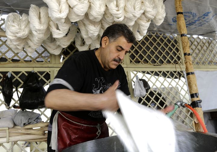 Mohamed al-Rihaoui lave ses fils de soie pour ôter les impuretés
 (LOUAI BESHARA / AFP)