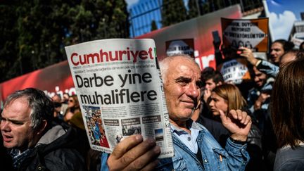 Des manifestants tenant le journal Cumhuriyet avec le titre "Pustch contre l'opposition" protestent contre l'arrestation des journalistes devant le siège du journal turc, lundi 31 octobre.&nbsp; (OZAN KOSE / AFP)