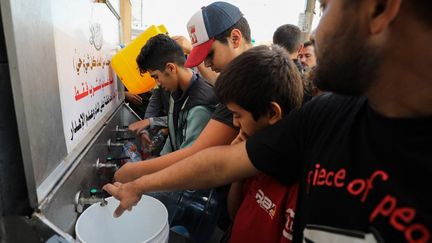 Des Palestiniens font la queue pour remplir des bidons d’eau dans la ville de Gaza, le 16 octobre 2023. (DAWOOD NEMER / AFP)