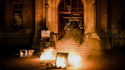 Un départ de feu devant la mairie du 4e arrondissement de Lyon, en marge d'une manifestation contre la réforme des retraites, le 17 mars 2023. (JEFF PACHOUD / AFP)