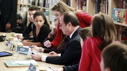 Fran&ccedil;ois Hollande choisit avec les enfants les photos pour le prochain num&eacute;ro du journal "Mon Quotidien", &agrave; Paris, le 22 janvier 2015. (REMY DE LA MAUVINIERE / AFP)