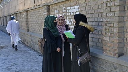 Des étudiantes discutent devant l'université de Kaboul (Afghanistan), le 26 février 2022. (AHMAD SAHEL ARMAN / AFP)