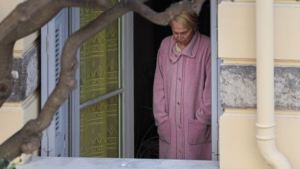 Une femme âgé confinée dans son appartement parisien regarde par la fenêtre. (ARI? BOTBOL / HANS LUCAS)