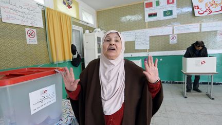 Dans un bureau de vote à Tunis lors de l'élection présidentielle du 21 décembre 2014. L'index gauche&nbsp;de l'électrice est maculé d'encre noire, preuve qu'elle a voté. (FETHI BELAID / AFP)