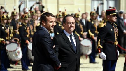 Le nouveau président de la République Emmanuel Macron et l'ancien président de la République , François Hollande, dans la cour de l'Elysée à Paris, le 14 mai 2017. (MAXPPP)