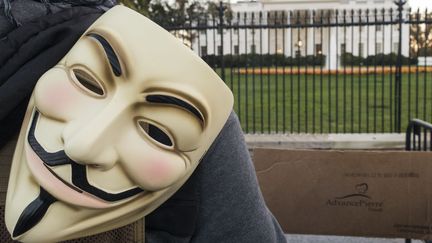 Masque habituellement par des hackers d'Anonymous, à côté de la Maison Blanche à Washington aux USA le 5 novembre 2015. (PAUL J. RICHARDS / AFP)