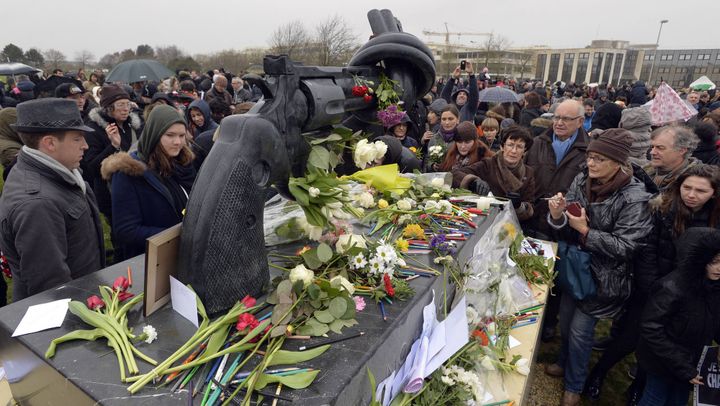 Mémorial de Caen, le 10 janvier 2015 : rassemblement sur l'esplanade du mémorial de Caen après les attentats des 7, 8 et 9 janvier. De nombreuses personnes viennent déposer des fleurs, des crayons et des dessins devant le revolver noué. C'est au Mémorial que se tiendront les rencontres internationales des dessinateurs de presse du 11 au 13 septembre prochains.
 (Stéphane Geufroi/PHOTOPQR/OUEST FRANCE)