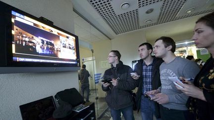 &nbsp; (Dans l'aéroport de Rostov sur le Don, des journalistes regardent sur un écran des images du crash © REUTERS)