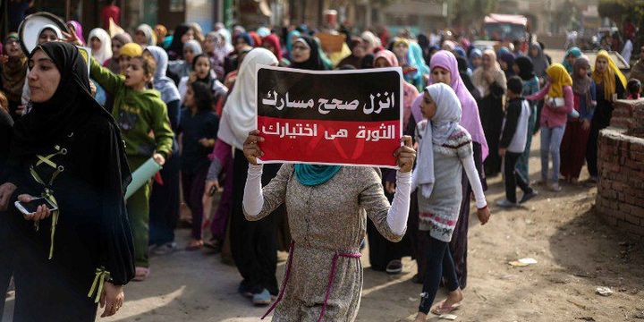 Des manifestants, le 11 novembre 2016, dans un quartier de Gizeh, près du Caire. Ils protestent contre les pénuries et les hausses de prix. «Manifeste pour le changement. La révolution est ton choix», peut-on lire sur la pancarte de la manifestante. (HESHAM FATHY / ANADOLU AGENCY)