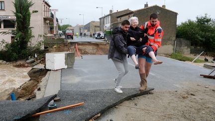 Une femme est évacuée, le 15 octobre 2018, à&nbsp;Villegailhenc (Aude), après des inondations. (ERIC CABANIS / AFP)