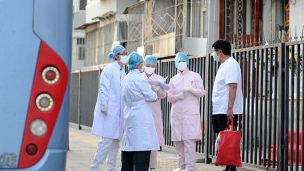 Le personnel d'un hôpital discute devant l'établissement, à Pékin, le 2 juillet 2009, en pleine épidémie de grippe.&nbsp; (AFP)