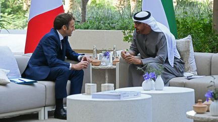 Emmanuel Macron et le prince héritier d'Abou Dhabi Mohammed ben Zayed présentent le contrat de vente des 80 Rafale.&nbsp; (AMMAR ABD RABBO / AFP)