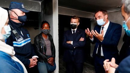 Emmanuel Macron et le maire de Montpellier, Michaël Delafosse, lors d'un échange avec des habitants du quartier de La Mosson, à Montpellier (Hérault), le 19 avril 2021. (GUILLAUME HORCAJUELO / AFP)