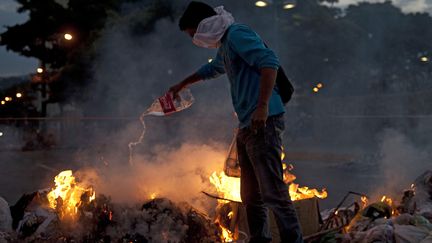 Un manifestant antigouvernemental allume un feu &agrave; Caracas, le 20 f&eacute;vrier 2014. (RAUL ARBOLEDA / AFP)