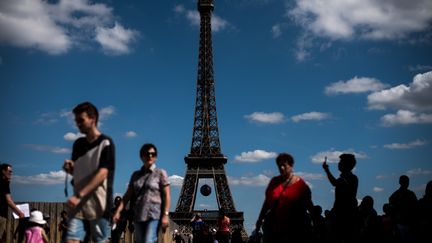 Des touristes au pied de la Tour Eiffel, le 9 juillet 2016, à Paris. (Photo d'illustration) (PHILIPPE LOPEZ / AFP)