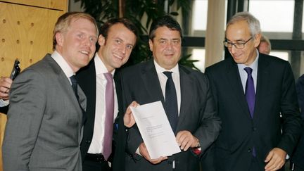 (De G. &agrave; D.) L'&eacute;conomiste Henrick Enderlein, le ministre de l'Economie fran&ccedil;ais,&nbsp;Emmanuel Macron, le ministre de l'Economie allemand,&nbsp;Sigmar Gabriel, et l'&eacute;conomiste Jean Pisani-Ferry, au moment de la remise du rapport franco-allemand, le 27 novembre 2014, &agrave; Paris. (ERIC PIERMONT / AFP)