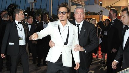 Johnny Deep encadré par quatre gardes du corps à sa sortie du Palais des Festivals à cannes en 2011
 (VALERY HACHE / AFP)