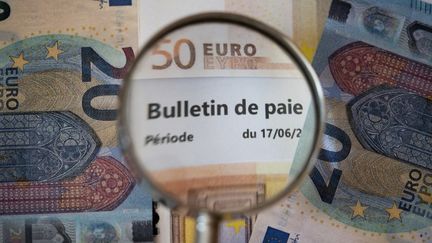 Un bulletin de paie et des billets, le 6 septembre 2022. (MAGALI COHEN / HANS LUCAS / AFP)