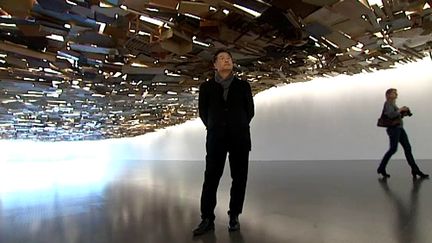 Tadashi Kawamata sous sa "vague de déchets" de Fukushima
 (France 3 / Culturebox)