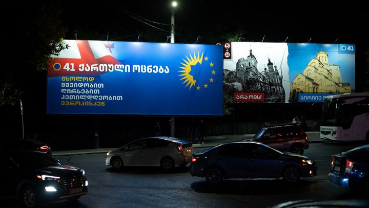 Une affiche électorale de Rêve géorgien mêle le logo du parti et les étoiles de l'UE, le 13 octobre 2024 à Tbilissi. A droite, une image d'église détruite en Ukraine, accompagnée du slogan "Dites non à la guerre, choisissez la paix". (MAURIZIO ORLANDO / HANS LUCAS VIA AFP)