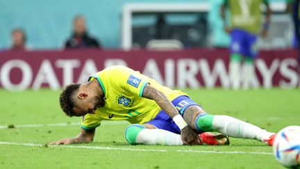 Le Brésil retient son souffle. Après un choc avec un défenseur serbe, Neymar se tient la cheville droite. Victime d’une entorse, il assiste du banc à la fin du match (victoire 2-0 des Brésiliens), le 24 novembre 2022. (JEAN CATUFFE / AFP)